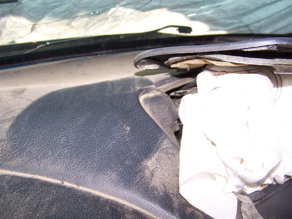 Dusty dashboard interior with a white cloth covering part of the windshield wiper assembly