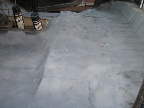 1978 Ford Bronco - The interior floor of a vehicle is shown, with two cans of spray paint visible.