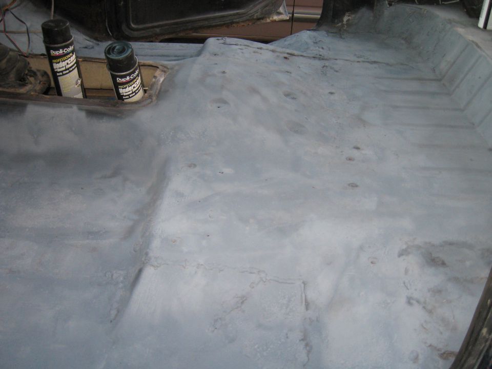 Interior floor of vehicle with two cans of spray paint
