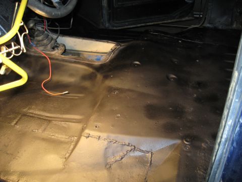 1978 Ford Bronco - The interior floor of a vehicle has been treated with black waterproofing material.