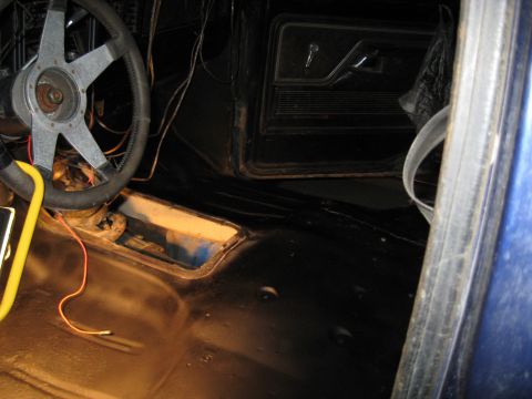1978 Ford Bronco - The interior of a vehicle is shown, focusing on the dashboard and driver's side door panel with exposed wiring.