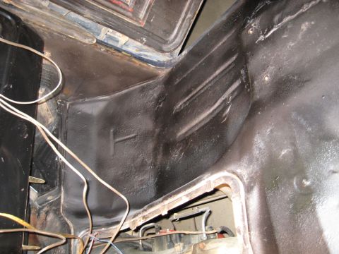 1978 Ford Bronco - Close-up view of the interior of a vehicle's body, highlighting the undercoating and wiring harness.