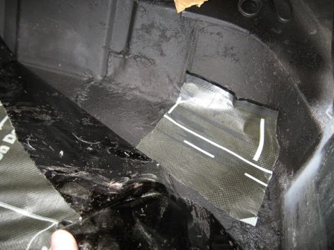 1978 Ford Bronco - Close-up view of sound deadening material and a patch of carbon fiber fabric in a vehicle's cargo area.