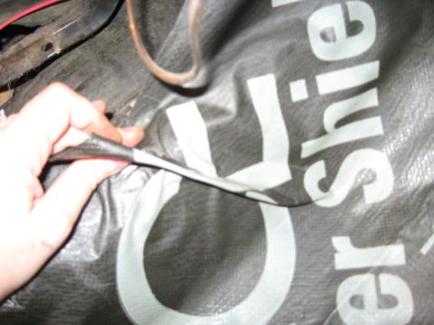 1978 Ford Bronco - A hand holds a black tarp with white lettering that appears to be part of a vehicle's interior or covering.