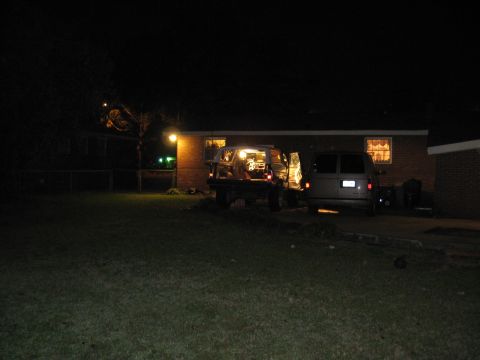 1978 Ford Bronco - Two vans are parked in a driveway at night, with one vehicle's rear hatch open.