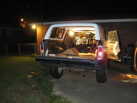 1978 Ford Bronco - Rear view of a 1978 Ford Bronco with its tailgate and driver's door open, illuminated from within.