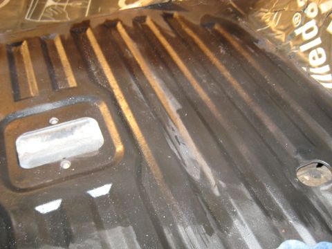 1978 Ford Bronco - The ribbed floor pan of a vehicle shows signs of sound deadening material installation.