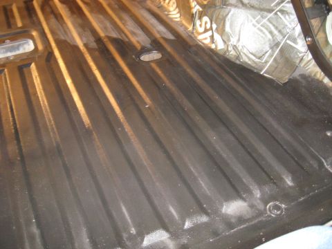 1978 Ford Bronco - The ribbed metal floor and sound deadening material are visible inside the vehicle's interior.