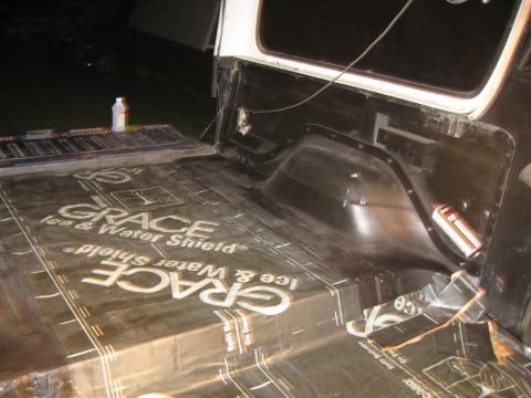 1978 Ford Bronco - Applying waterproofing material to the interior of a vehicle's cargo area.
