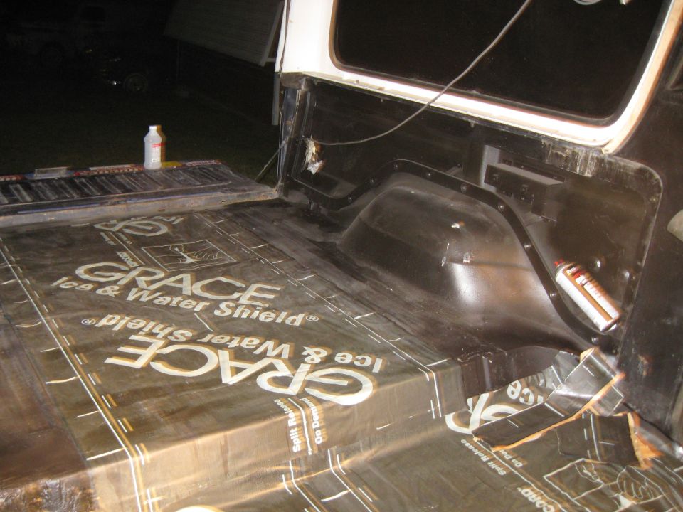 Vehicle cargo area being lined with Grace Ice & Water Shield material. Spray can and bottle visible