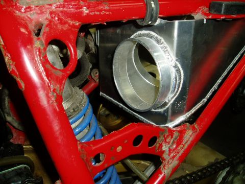 2000 Ford E350 - Custom aluminum intake tube installation on a red frame, blue suspension components.