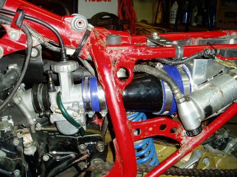 2000 Ford E350 - Close-up view of a motorcycle's engine components, a carburetor and intake system with blue accents.