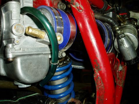 2000 Ford E350 - Detail of a carburetor and suspension system, a blue spring and red frame components.