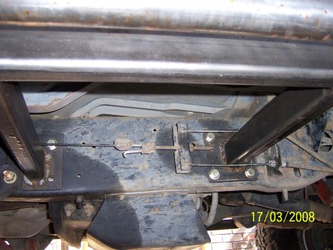1991 Ford Bronco - Close-up view of the undercarriage, highlighting the installation of custom rock sliders and associated hardware.