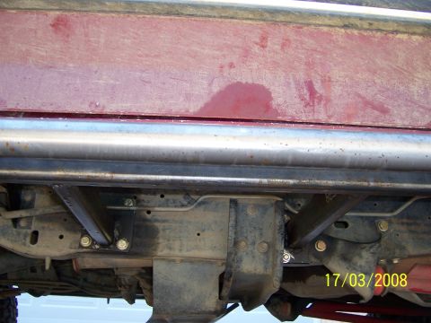 1991 Ford Bronco - Close-up view of the undercarriage and custom sliders on a red vehicle.