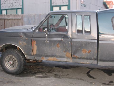 1990 Ford F-250 - This 1990 Ford F-250 shows extensive rust damage along its lower body panels and doors.