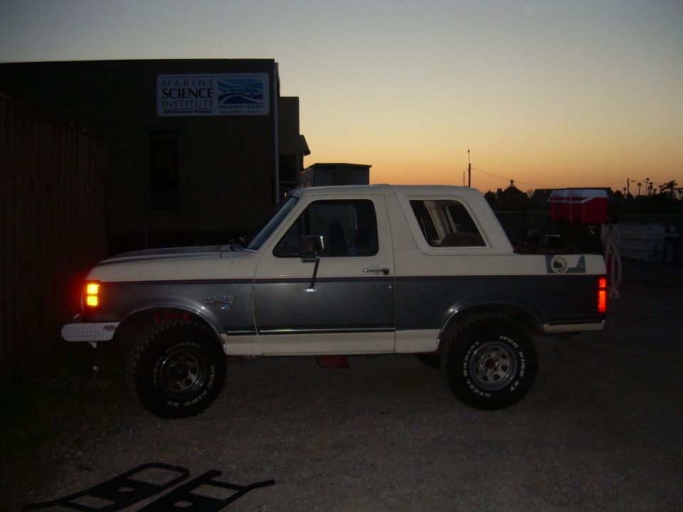 1991 Ford Bronco parked outside a building at dusk