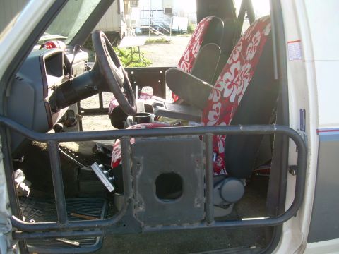 1991 Ford Bronco - Modified 1991 Ford Bronco interior shows custom roll cage and Hawaiian print seat covers.