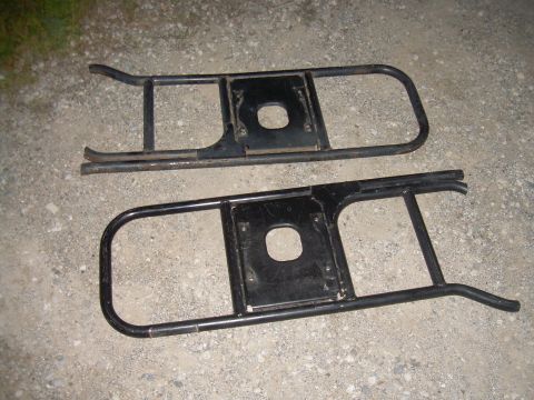 1991 Ford Bronco - Two black metal running boards are shown from a top-down perspective on a gravel surface.