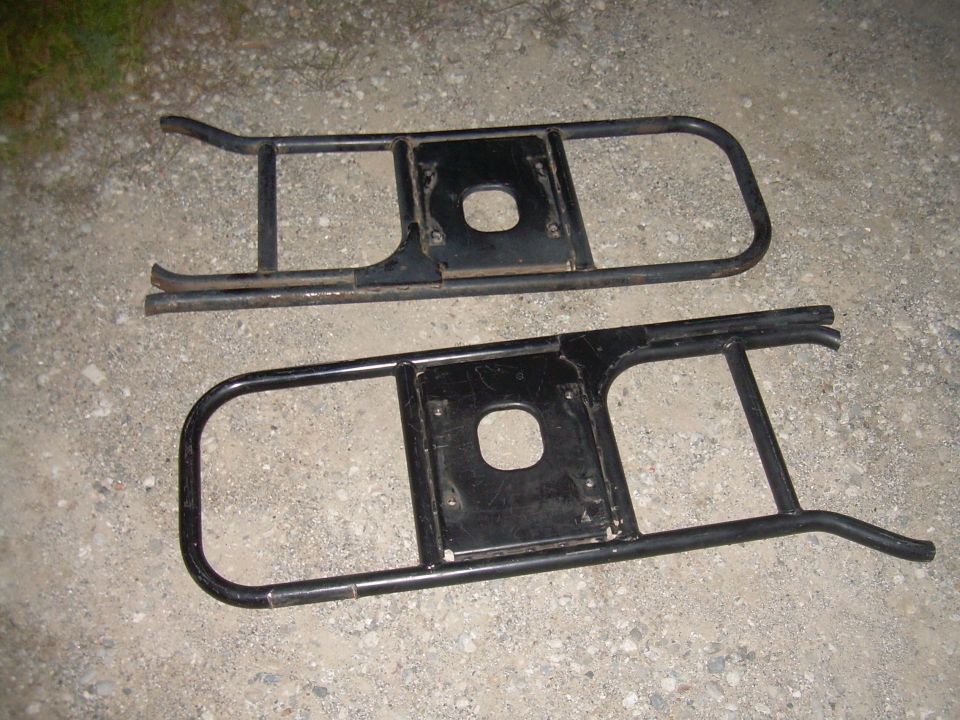 Pair of black metal running boards with square cutouts for mounting