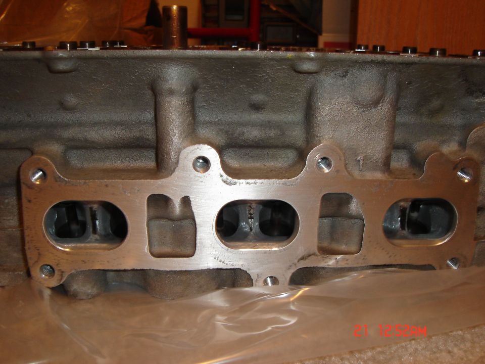 Engine cylinder head with intake manifold gasket showing four ports