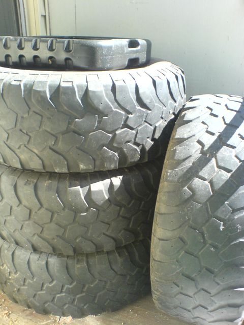 1985 Ford Bronco - A stack of four off-road tires is shown, with one tire on top a distinct tread pattern.