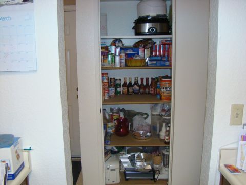 1989 Ford Bronco - A pantry is filled with various food items, drinks, and kitchen appliances on shelves.