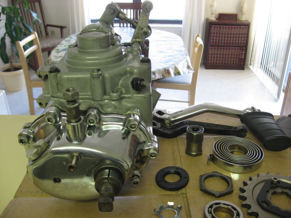 Disassembled gearbox or transmission case with springs and parts on a wooden table