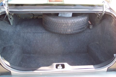2001 Ford Crown Victoria - The trunk of a car, with a spare tire visible in its compartment.
