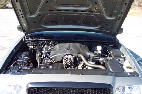 2001 Ford Crown Victoria - The engine bay of a 2001 Ford Crown Victoria, showing the V8 engine and surrounding components.