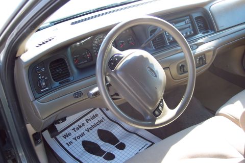 2001 Ford Crown Victoria - Interior view of a 2001 Ford Crown Victoria, showing the dashboard, steering wheel, and floor mat.
