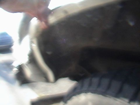 1990 Ford Bronco - A close-up view of a tire within a vehicle's wheel well, showing part of the fender liner.