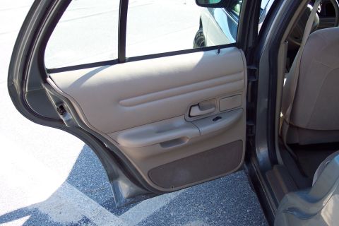 2001 Ford Crown Victoria - Interior view of a 2001 Ford Crown Victoria, showing the tan door panel and seat.