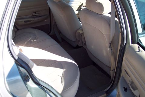 2001 Ford Crown Victoria - Rear interior view of a 2001 Ford Crown Victoria, tan cloth seats and door panels.