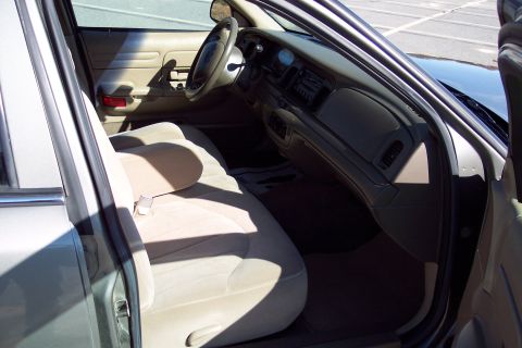 2001 Ford Crown Victoria - Interior view of a 2001 Ford Crown Victoria, showing tan cloth seats and the dashboard.