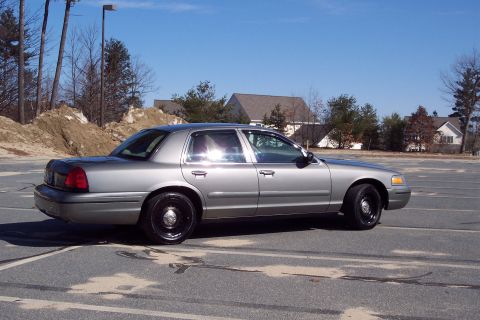 2001 Ford Crown Victoria - Side profile of a silver 2001 Ford Crown Victoria sedan on a clear day.
