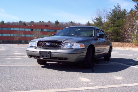 2001 Ford Crown Victoria - A 2001 Ford Crown Victoria is shown from the front-right in a parking lot with a building in the background.