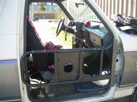 1991 Ford Bronco - The interior of a truck shows a custom roll cage, seat covers, and dashboard details.