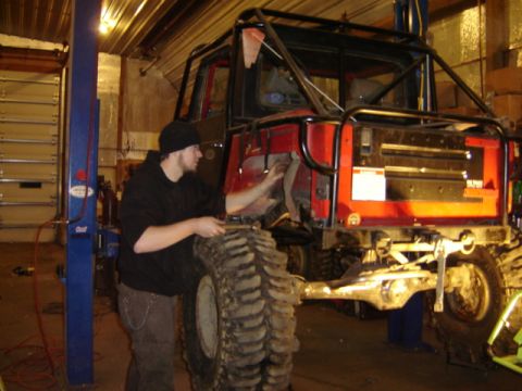 1992 Ford Bronco - A heavily modified off-road vehicle is undergoing maintenance in a garage.