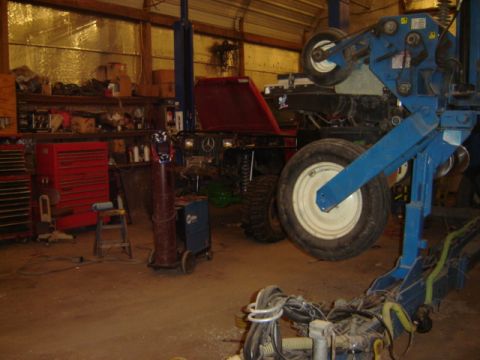 1992 Ford Bronco - Vehicle undergoing maintenance in a workshop, surrounded by tools and machinery.