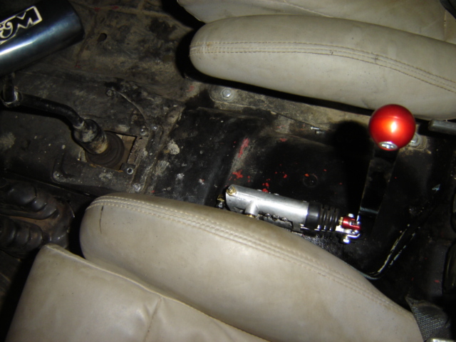 Vehicle interior showing a red ball shifter and a hydraulic clutch master cylinder