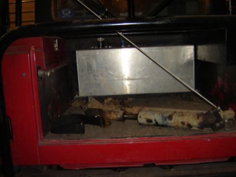 1992 Ford Bronco - The rear interior of a vehicle displays a large auxiliary fuel tank and suspension parts.