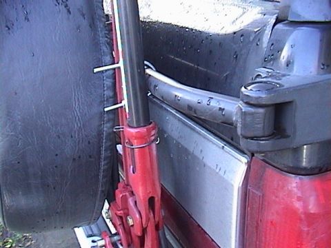1990 Ford Bronco - Close-up of a Hi-Lift jack mounted on the exterior of a vehicle.