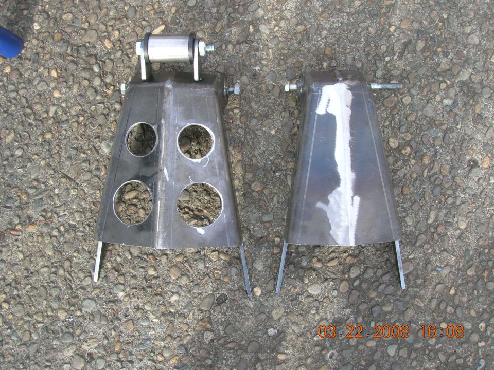 Two metal brackets with circular cutouts and a roller assembly
