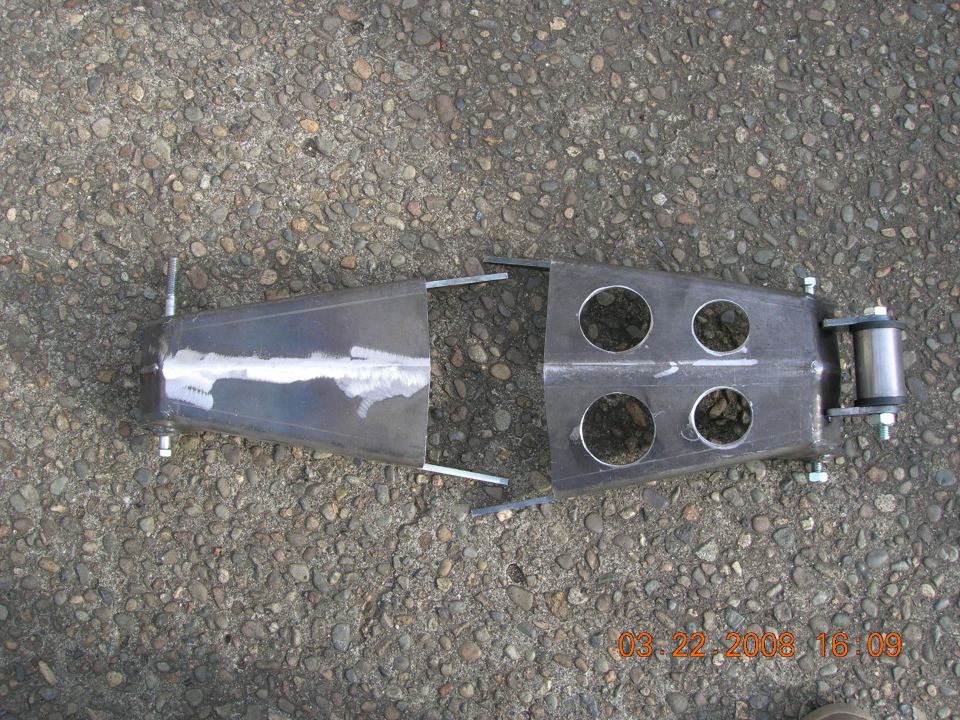 fabricated metal suspension component with four circular cutouts and a roller assembly