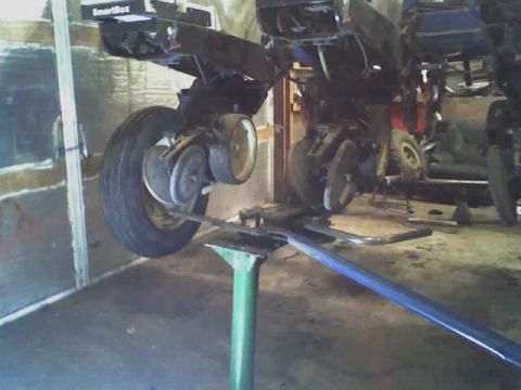 1992 Ford Bronco - A vehicle is elevated on a lift, revealing its undercarriage and suspension system for maintenance.