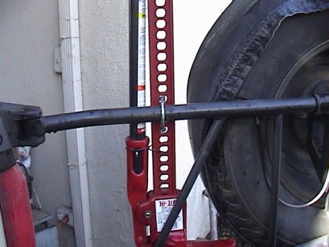 1990 Ford Bronco - A Hi-Lift jack is shown mounted to a vehicle's frame, adjacent to the spare tire.