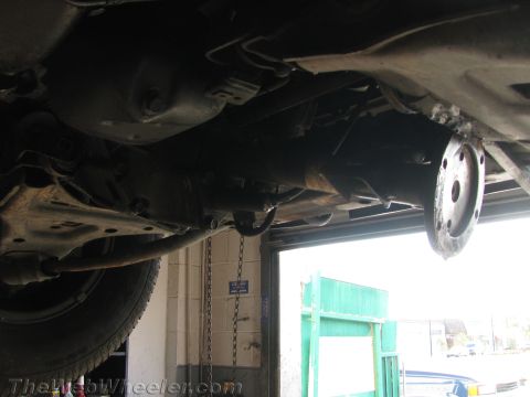 1987 Suzuki Samurai - The undercarriage of a vehicle is shown, focusing on the transmission and associated components.
