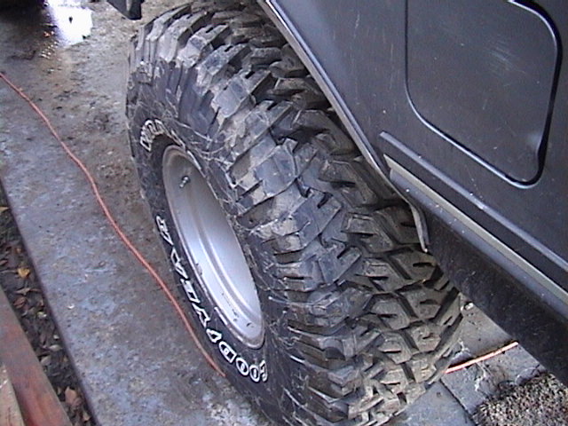 Black tire with "Goodyear" text and aggressive tread pattern on a dark vehicle fender