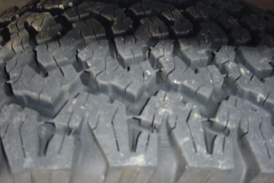 Close-up of tire tread with "SUPERMOTORS" logo visible
